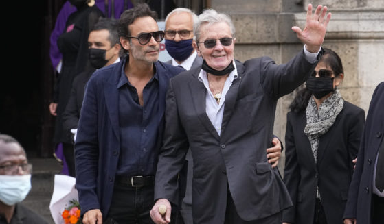 French actor Alain Delon and his son Anthony Delon, left, are seen in a file photo from September. Alain Delon's children are accusing his partner of bullying the 87-year-old French film star and of cruelty toward his dog — legal complaints that a French prosecutor has now directed police to investigate.