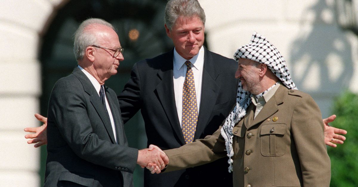 U.S. President Bill Clinton stands between Israeli Prime Minister Yitzahk Rabin, left, and Palestine Liberation Organization leader Yasser Arafat as they shake hands on Sept. 13, 1993, at the White House in Washington, D.C., after signing the Oslo Accords.