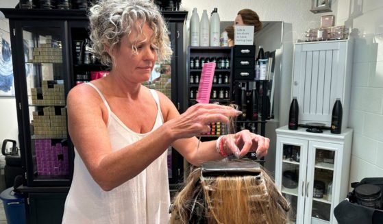 Christine Geiger cuts a customer's hair at her salon on Wednesday in Traverse City, Michigan.