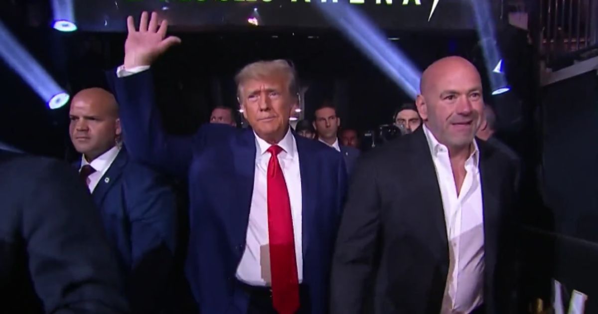 Former President Donald Trump, middle, arrives at UFC 290 with UFC President Dana White, right, at T-Mobile Arena in Las Vegas on Saturday.