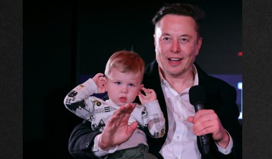 Elon Musk and son X Æ A-12 ("X" for short) are pictured in December 2021. Musk appeared to hint in a recent tweet that he would support voting rights being restricted to those with children