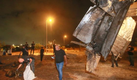 Israeli authorities inspect the remains of what the Israeli military said is a Syrian anti-aircraft rocket that exploded in the air, in the town of Rahat, Israel, on Sunday.