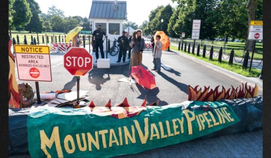 Activists with the indigenous environmental network block an entrance to the White House as they protest the Mountain Valley Pipeline in a file photo from June 2021. The Supreme Court is allowing construction to resume on the contested natural-gas pipeline that is being built through Virginia and West Virginia. Work had been halted by the federal appeals court in Richmond, even after Congress ordered the project's approval as part of the bipartisan bill to increase the debt ceiling. President Joe Biden signed the bill into law in June.