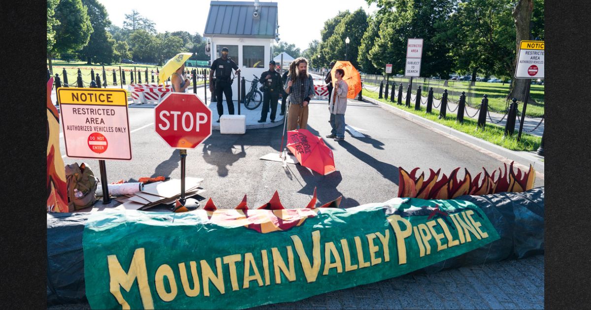 Activists with the indigenous environmental network block an entrance to the White House as they protest the Mountain Valley Pipeline in a file photo from June 2021. The Supreme Court is allowing construction to resume on the contested natural-gas pipeline that is being built through Virginia and West Virginia. Work had been halted by the federal appeals court in Richmond, even after Congress ordered the project's approval as part of the bipartisan bill to increase the debt ceiling. President Joe Biden signed the bill into law in June.