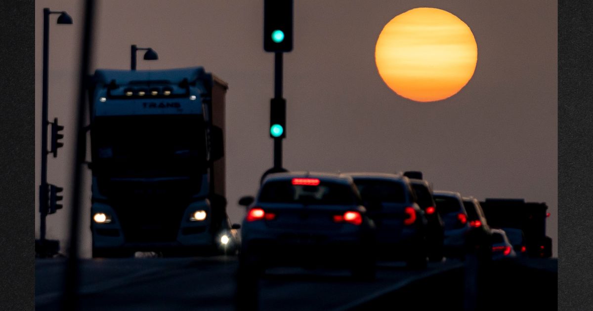 Cars drive as the sun rises amidst clouds of dust coming from the Sahara in the coastal city of Koge, Denmark, in a file photo from February 2021. A similar Saharan dust cloud is making its way toward the U.S.