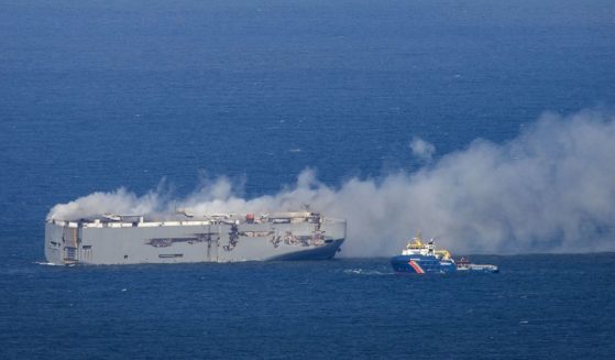 A Dutch coast guard boat approaches the Panamanian-registered car carrier cargo ship Fremantle Highway on fire off the coast of the northern Dutch island of Ameland on Wednesday.