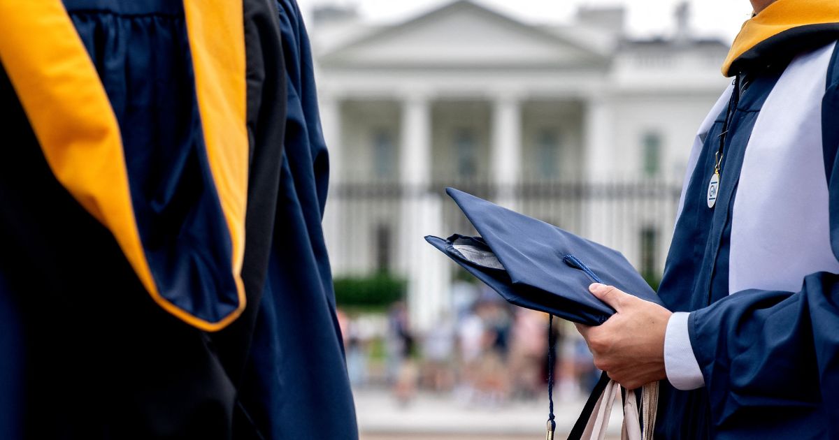 Students from George Washington University wear their graduation gowns outside of the White House in Washington, D.C., on May 18, 2022.