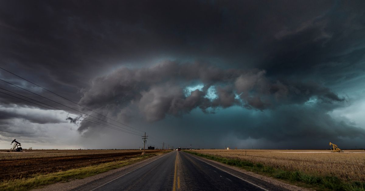 A road vanishes into the distance under a super cell storm in Texas.