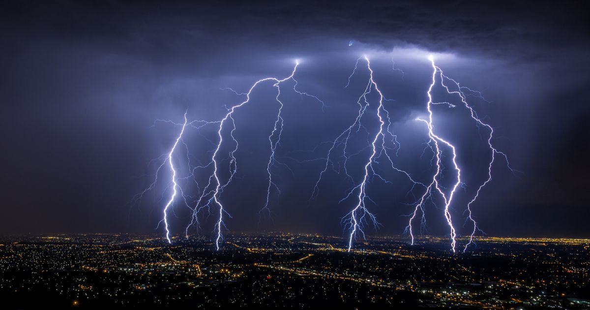 This stock photo shows lightening striking over a city.