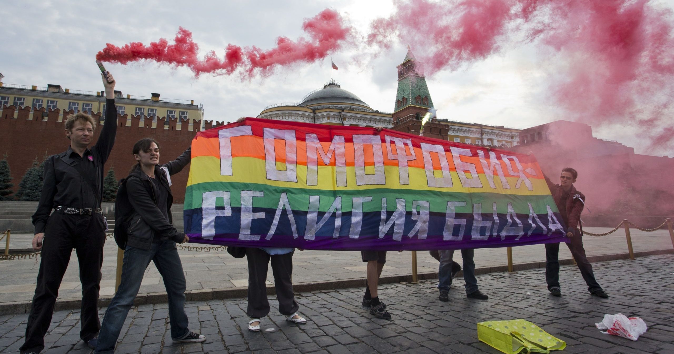 LGBT activists hold a banner reading "Homophobia - the religion of bullies" during a protest in Moscow's Red Square on July 14, 2013.