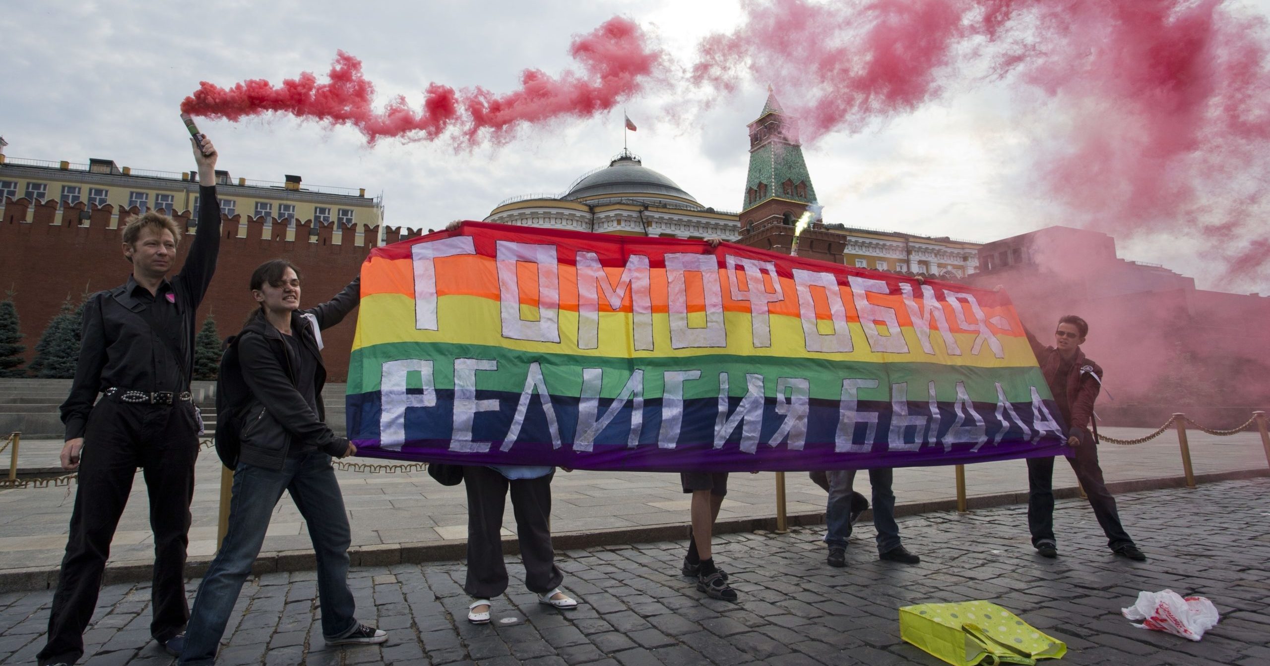 LGBT activists hold a banner reading "Homophobia - the religion of bullies" during a protest in Moscow's Red Square on July 14, 2013.