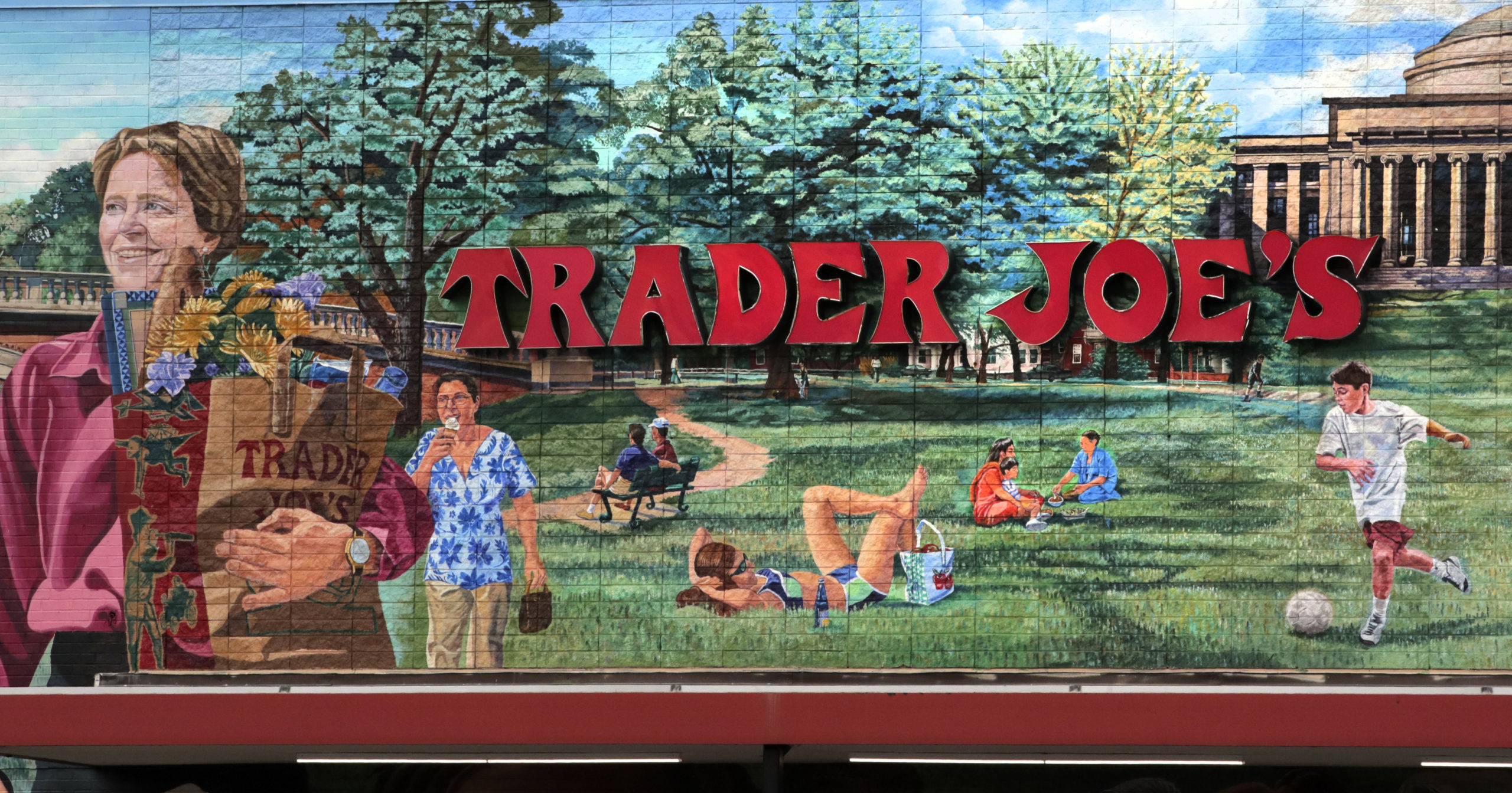In this Aug. 13, 2019, file photo, Trader Joe’s logo hangs on a mural at it’s market in Cambridge, Massachusetts.