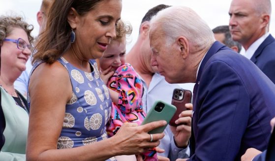 President Joe Biden talks to a child as he greets embassy staff members and their families before boarding Air Force One at Helsinki-Vantaan International Airport in Helsinki, Finland, Thursday.