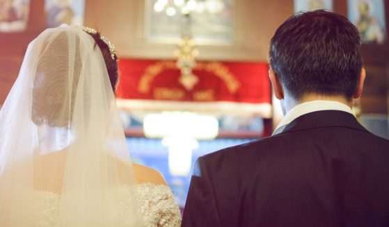 A bride and groom pictured from behind.