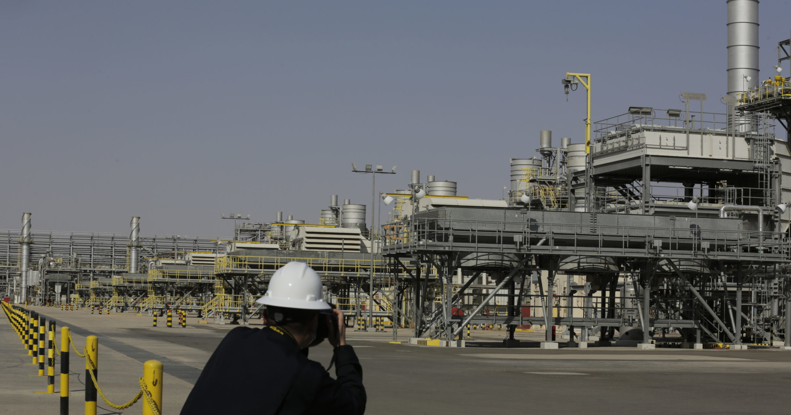 A photographer takes pictures of the Khurais oil field in Saudi Arabia during a tour for journalists on June 28, 2021.
