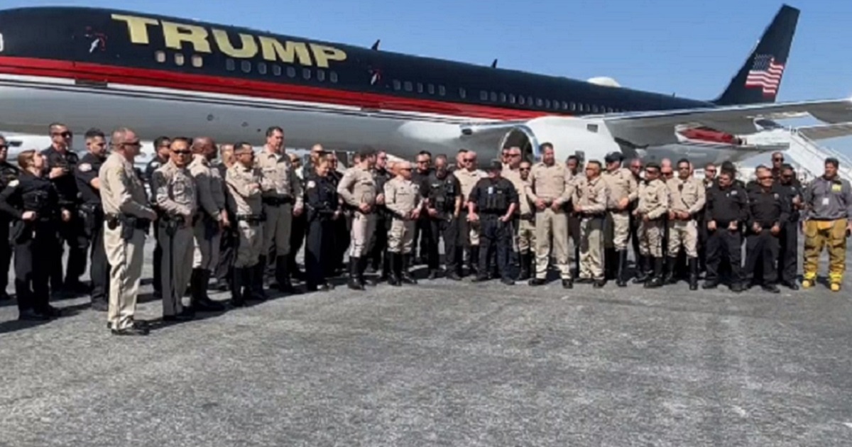 Law enforcement personnel gather to greet former President Donald Trump Sunday at Los Angeles International Airport.
