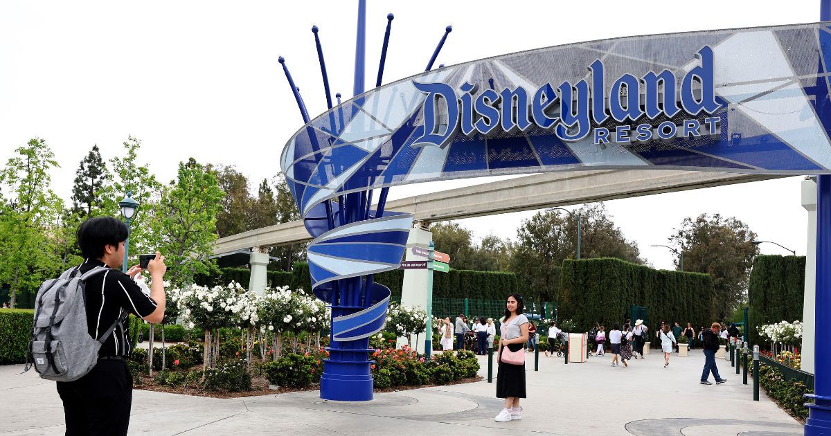 Visitors take a photo at an entrance to Disneyland on April 24 in Anaheim, California.