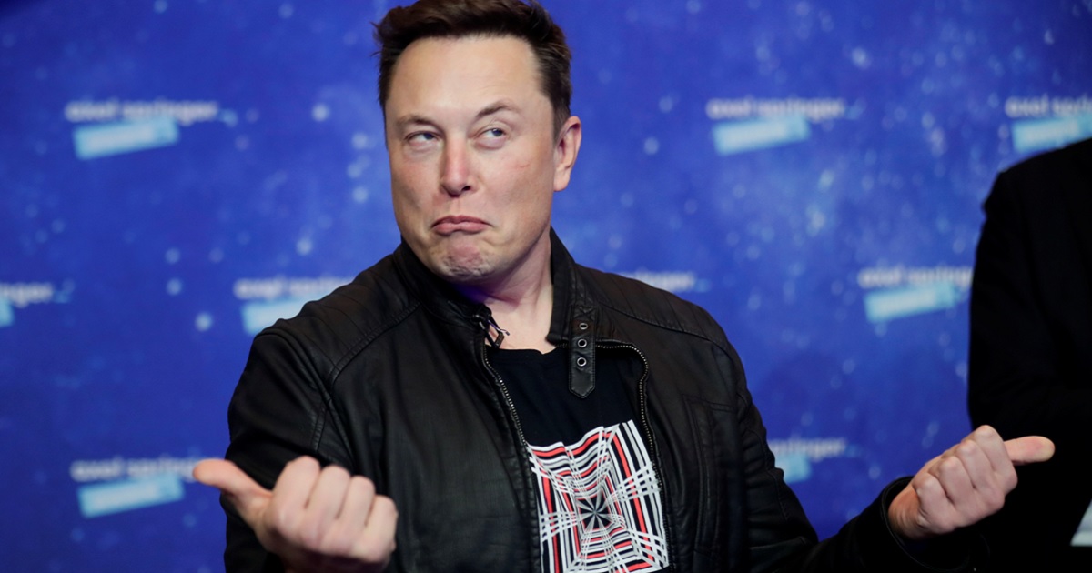 Mega-billionaire Elon Musk, owner of X, the company formerly known as Twitter, makes a face and jerks both thumbs outward in a file photo from December 2020 in Berlin.