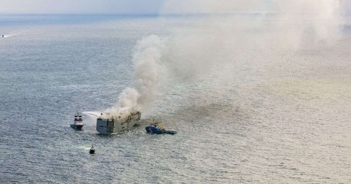 This aerial photograph shows emergency boats extinguishing a fire aboard the Panamanian-registered car carrier cargo ship Fremantle Highway, off the coast of the northern Dutch island of Ameland.