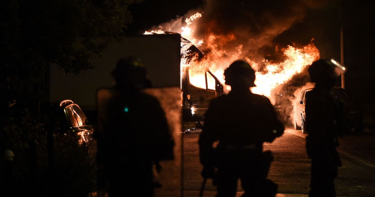French anti-riot police officers watch a truck burn in Nantes, western France, on Saturday.