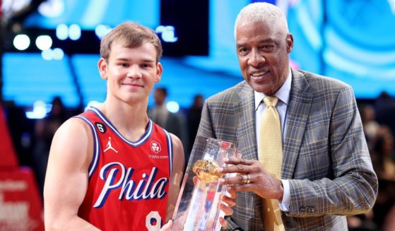 Mac McClung of the Philadelphia 76ers, left, and former professional basketball player Julius Erving, right, pose with the trophy after McClung's victory in the 2023 NBA All Star AT&T Slam Dunk Contest at Vivint Arena Salt Lake City, Utah, on Feb. 18.