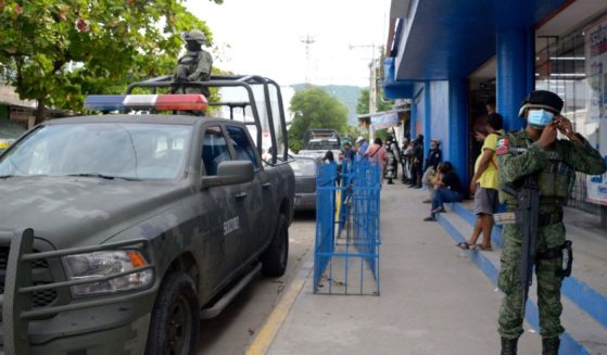Mexican Army soldiers check the area where Mexican journalist Nelson Mateus was murdered in the resort town of Acapulco, Guerrero state, Mexico, on Saturday.