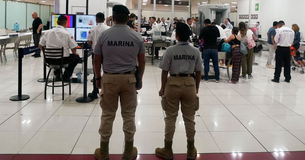 Mexican Navy officers stand guard next to a security checkpoint at the Benito Juarez International Airport, in Mexico City, on June 30.