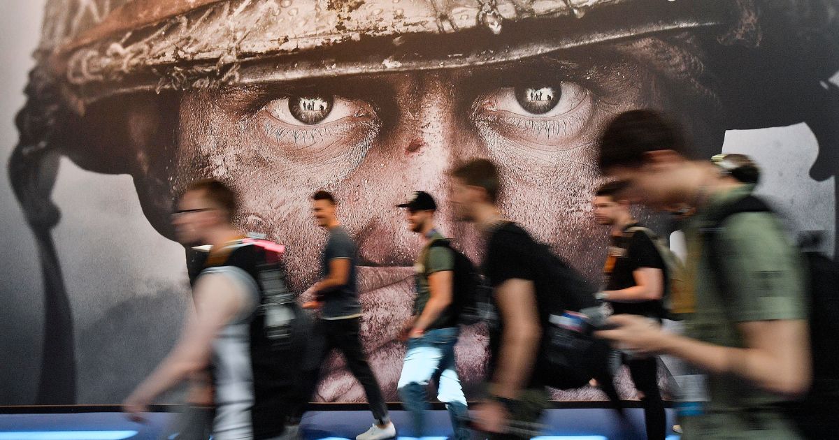 Visitors passing an advertisement for the video game 'Call of Duty' at the Gamescom fair for computer games in Cologne, Germany, Aug. 22, 2017.