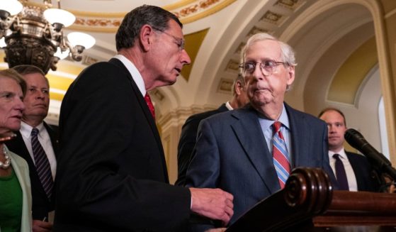 Sen. John Barrasso (R-WY) reaches out to help Senate Minority Leader Mitch McConnell (R-KY) after McConnell froze and stopped talking at the microphones during a news conference after a lunch meeting with Senate Republicans U.S. Capitol on Wednesday in Washington, D.C.