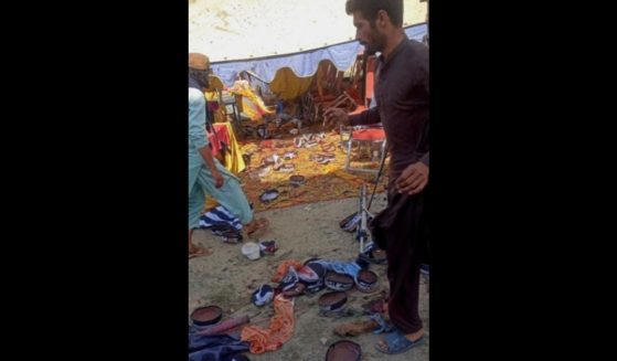 Men gather at the site of a bomb blast in Bajaur district on July 30, 2023. At least 16 people were killed and dozens more wounded on July 30 by a bomb blast at a political gathering of a radical Islamic party in northern Pakistan, police said.