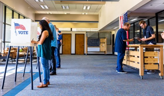 Voters in a stock photo of a polling place.
