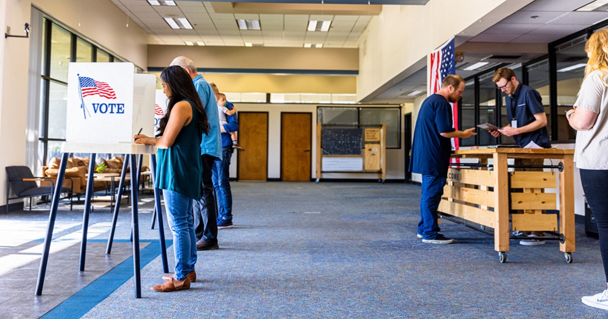 Voters in a stock photo of a polling place.