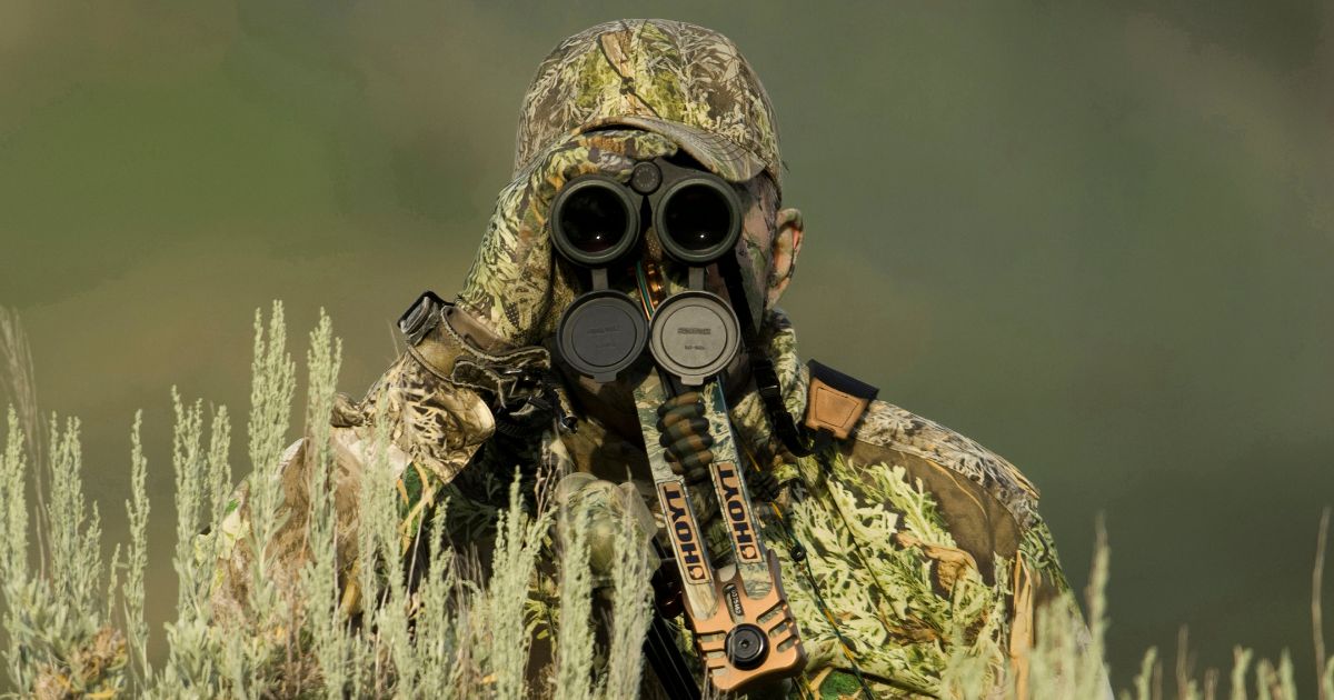 This stock image shows a hunter in camo peering through binoculars.