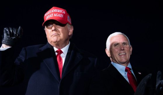 Then-President Donald Trump, left, arrives with then-Vice President Mike Pence, right, for a Make America Great Again rally at Cherry Capital Airport in Traverse City, Michigan on Nov. 2, 2020.