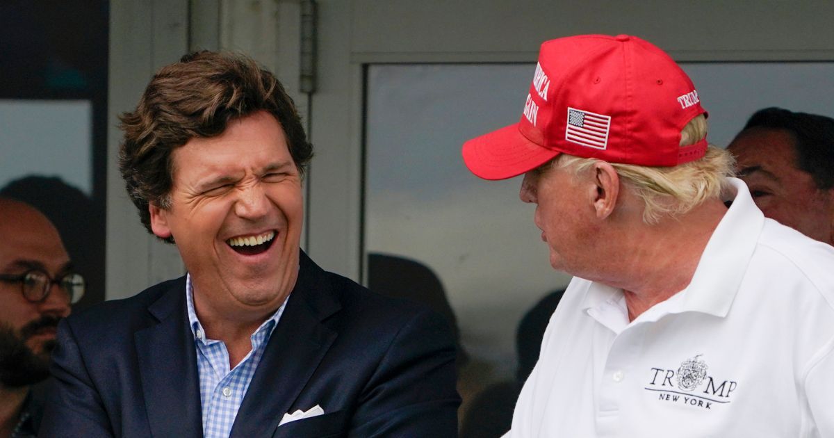 Tucker Carlson, left, and former President Donald Trump react during the final round of the Bedminster Invitational LIV Golf Tournament in Bedminster, New Jersey, on July 31, 2022.