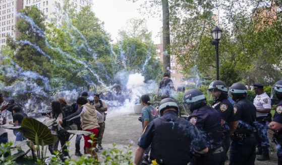 Police officers set off a smoke bomb in order to disperse a mob on Friday in New York's Union Square.