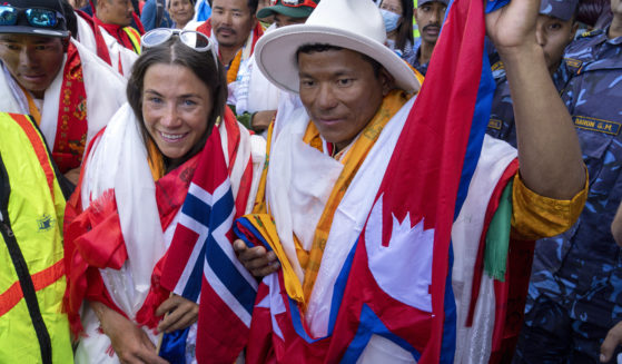 Norwegian climber Kristin Harila, left, and her Nepali sherpa guide Tenjin Sherpa, right, who climbed the world’s 14 tallest mountains in record time, arrive in Kathmandu, Nepal, on Aug. 5.