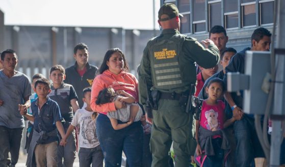 Migrants are loaded onto a bus by U.S. Border Patrol agents in El Paso, Texas, after being detained when they crossed into the United States from Mexico in a file photo from 2019.