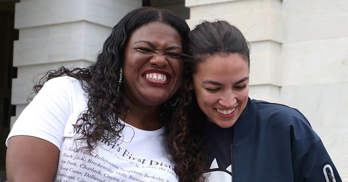 Democratic Reps. Cori Bush, left, and Alexandria Ocasio-Cortez share a laugh on the steps of the U.S. Capitol in Washington on Aug. 3, 2021.