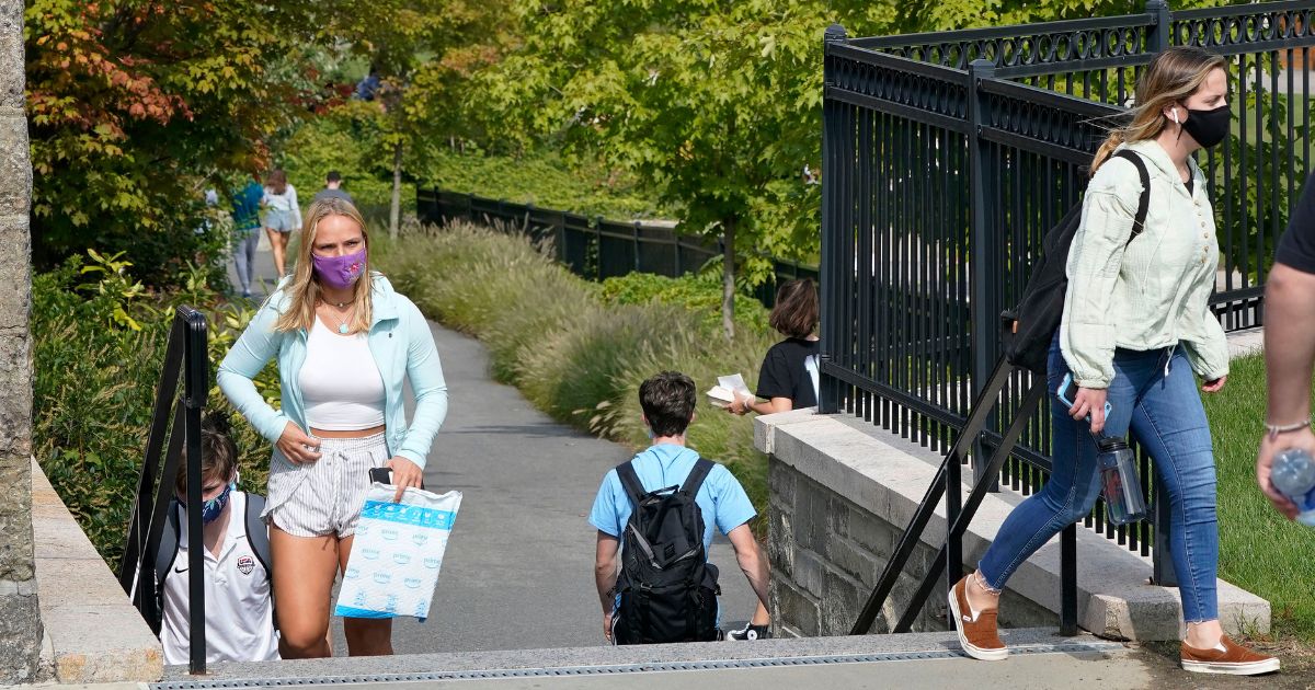 Students wear masks at the Boston College campus in Boston during the coronavirus pandemic on Sept. 17, 2020.