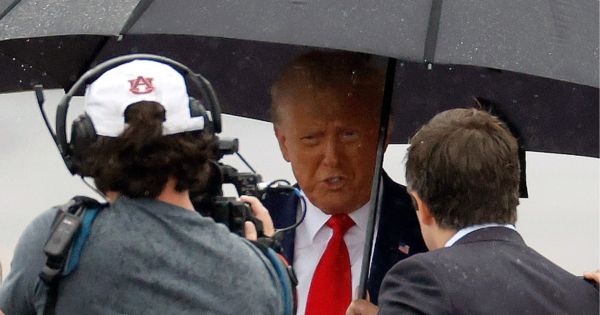 Former President Donald Trump talks with members of the media on the tarmac at Reagan National Airport following his Thursday arraignment in Washington, D.C.