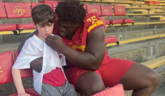 On Friday, the Iowa State football program hosted Victory Day for children with special needs. Player Oluwafunto Akinshilo, right, took the time to help Colt Cosper, left, and the boy's mother captured the sweet moment.