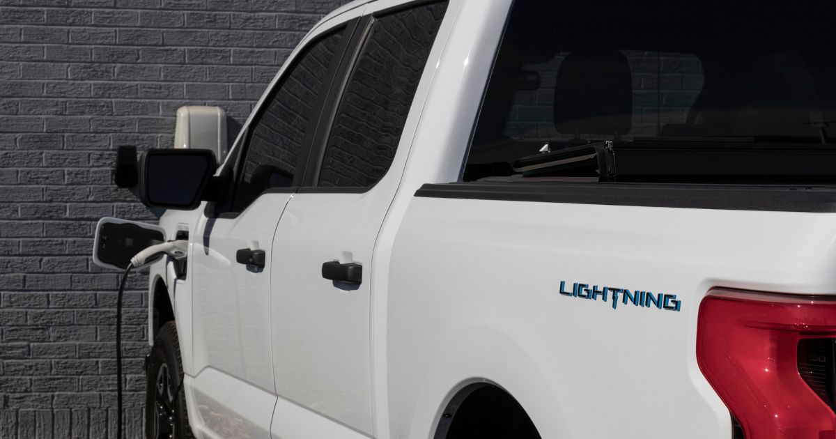 A stock photo from October 2022 shows a Ford F-150 Lightning pickup at a charging station.