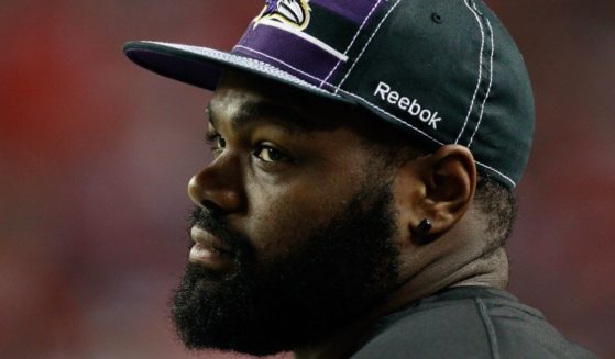 Then Baltimore Raven Michael Oher watches the game against the Atlanta Falcons from the bench in Atlanta, Georgia, on Sept. 1, 2011.