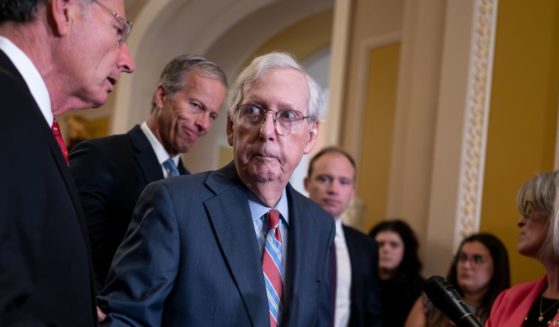 Mitch McConnell being helped by other senators after freezing at the podium