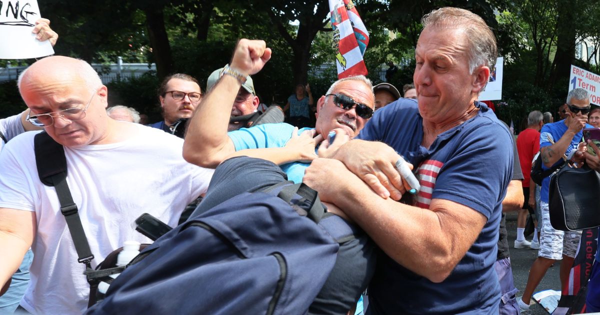 A protester grabs a counterdemonstrator during a rally against the city's handling of illegal immigrants outside of Gracie Mansion in New York on Sunday.
