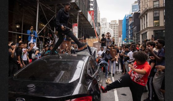 People jump on a car during riots sparked by Twitch streamer Kai Cenat, who announced a giveaway event in New York's Union Square on Aug. 4. Around 2,000 young people showed up at the gathering, which degenerated into street violence and left a number of people injured, police said.