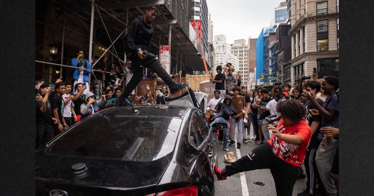 People jump on a car during riots sparked by Twitch streamer Kai Cenat, who announced a giveaway event in New York's Union Square on Aug. 4. Around 2,000 young people showed up at the gathering, which degenerated into street violence and left a number of people injured, police said.