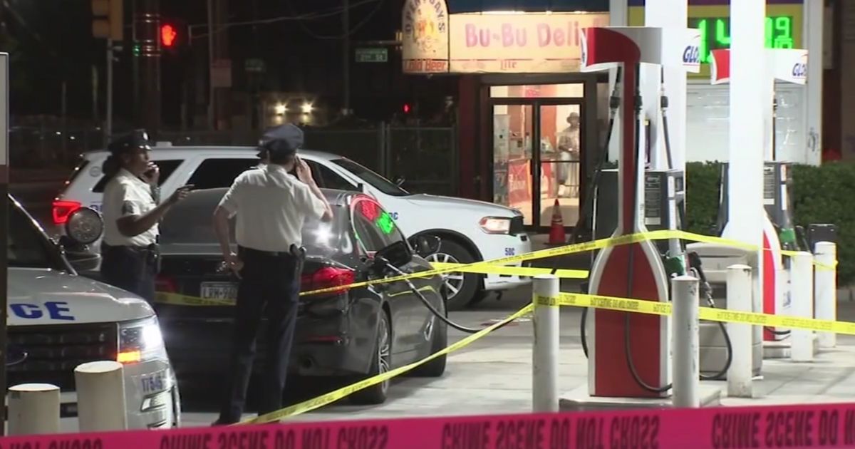Philadelphia police are seen at the crime scene, a gas station where a car owner was attacked Tuesday.