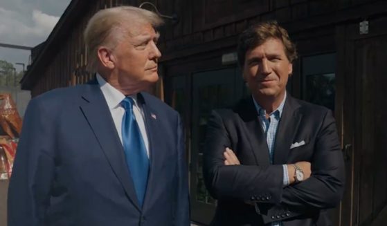 Former President Donald Trump stands with Tucker Carlson before their interview on X.